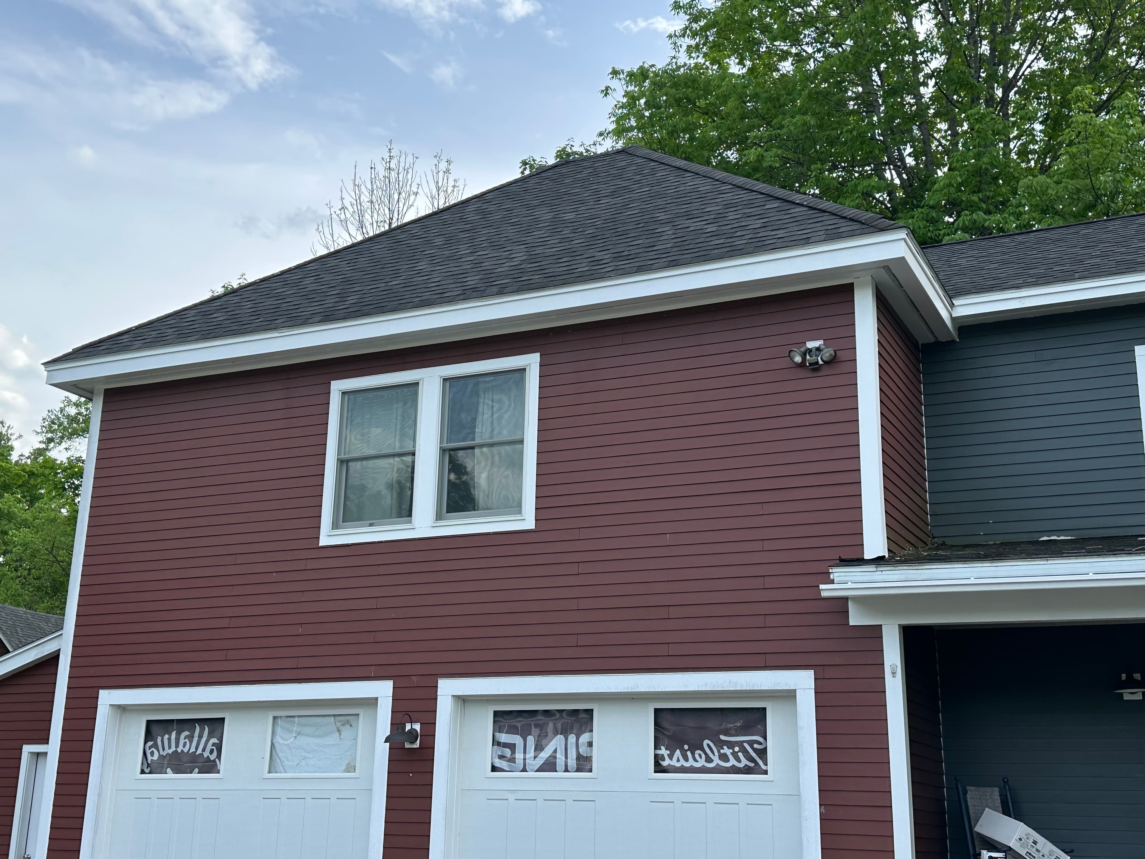 Red house with white trim and garage doors featuring Callaway, PING, and Titleist signs.